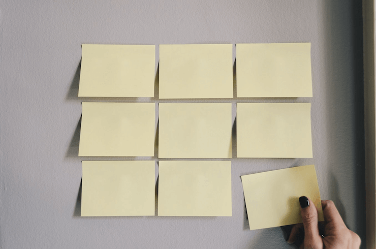 A man taking yellow sticker from a board