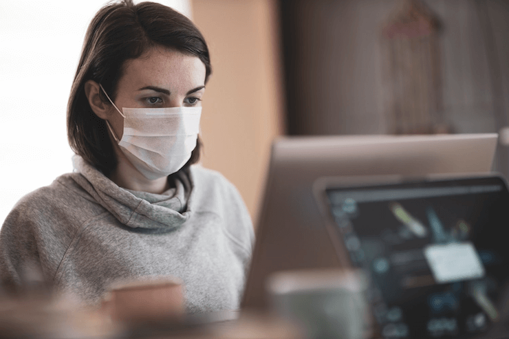 A woman works in the office and wears a mask